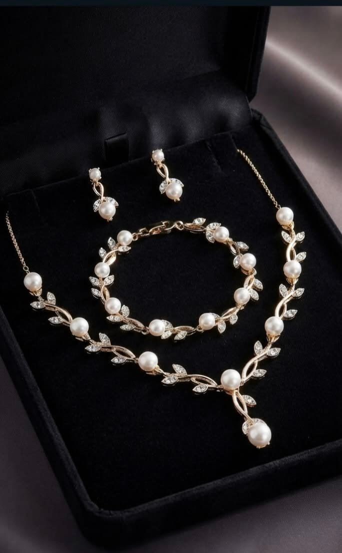 Gold pearl and leaf jewelry set with necklace, bracelet, and earrings